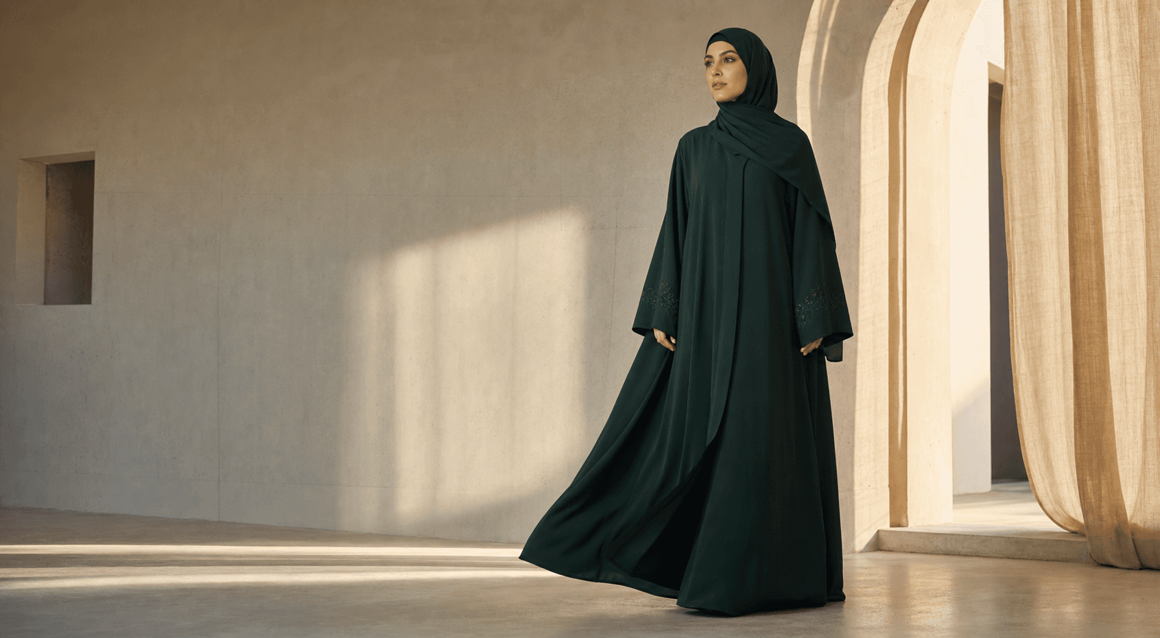 Abaya émeraude fluide dans une architecture minérale